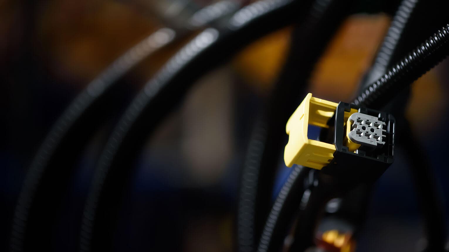 Yellow multi-pin plug on a black wiring harness